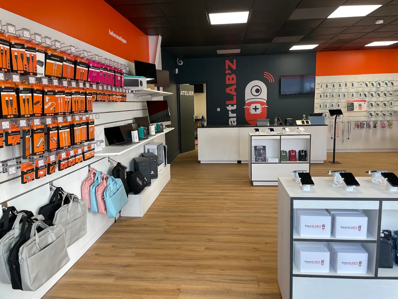 Intérieur de la boutique : rayon informatique, comptoir et porte de l'atelier